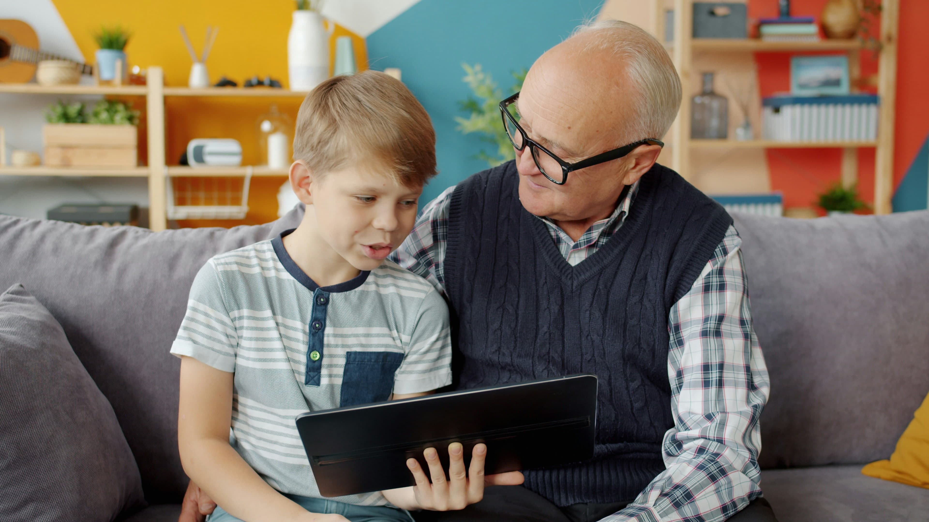 A child and caregiver exploring a tablet together